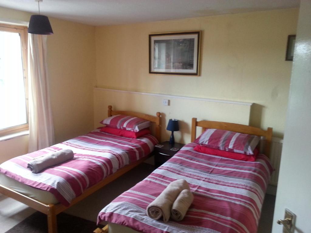 a bedroom with two beds and two lamps at Ostler Inn in Uffculme