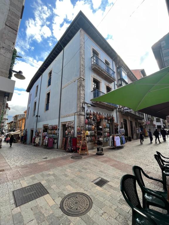 a large white building with a store on a street at Apartamento en el centro de Llanes in Llanes