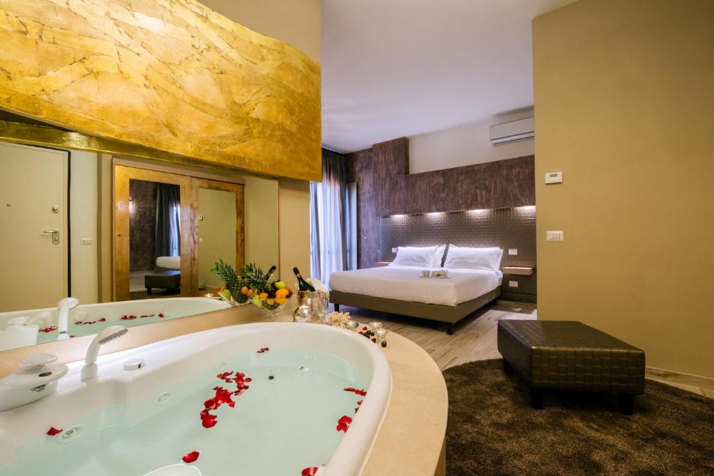 Habitación de hotel con bañera y cama en Le Dimore Del Re, en Trani