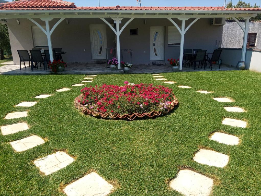 a garden in front of a house with a flower bed at De plata apartments in Sarti