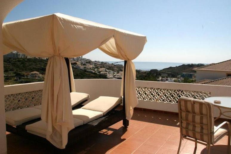 a patio with an umbrella and chairs on a balcony at Villa Cerro in Albufeira