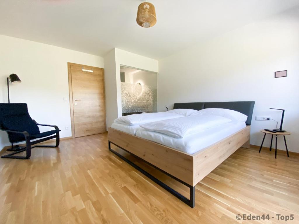 塔姆斯韋格的住宿－Eden 44 - Top 5，一间卧室配有一张大床和一把椅子