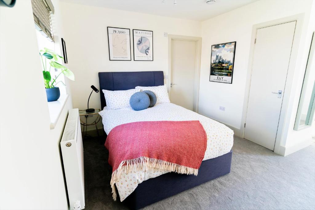 a bedroom with a bed with a blue headboard at Elm Cottage at Gravel Farm in Stretham
