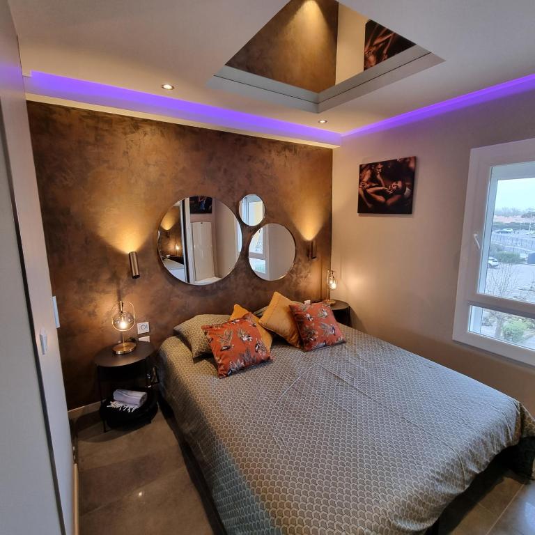 - une chambre avec un grand lit et deux miroirs dans l'établissement Le DESIR Port Nature 4 Coursives -vue mer, au Cap d'Agde