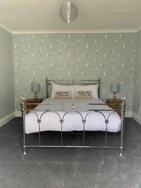 a bedroom with a bed with birds on the wall at The Wylfa in Abersoch