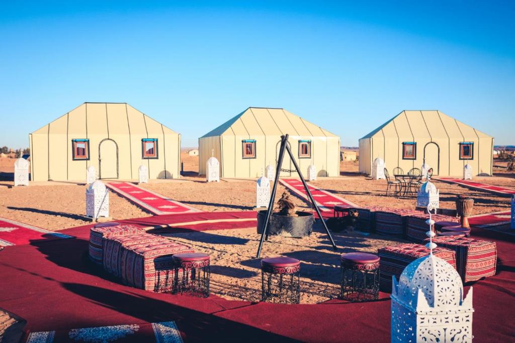 a set of play tents with tables and chairs in front at Luxury Desert Camp Amanar in Merzouga
