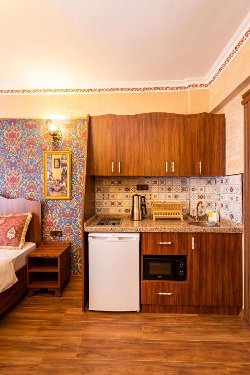 a kitchen with wooden cabinets and a white refrigerator at The First Ottoman Dream in Istanbul