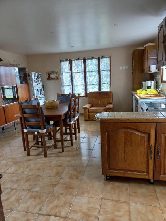 une cuisine et une salle à manger avec une table et des chaises dans l'établissement Perrot Henry, à Saint-Marcouf
