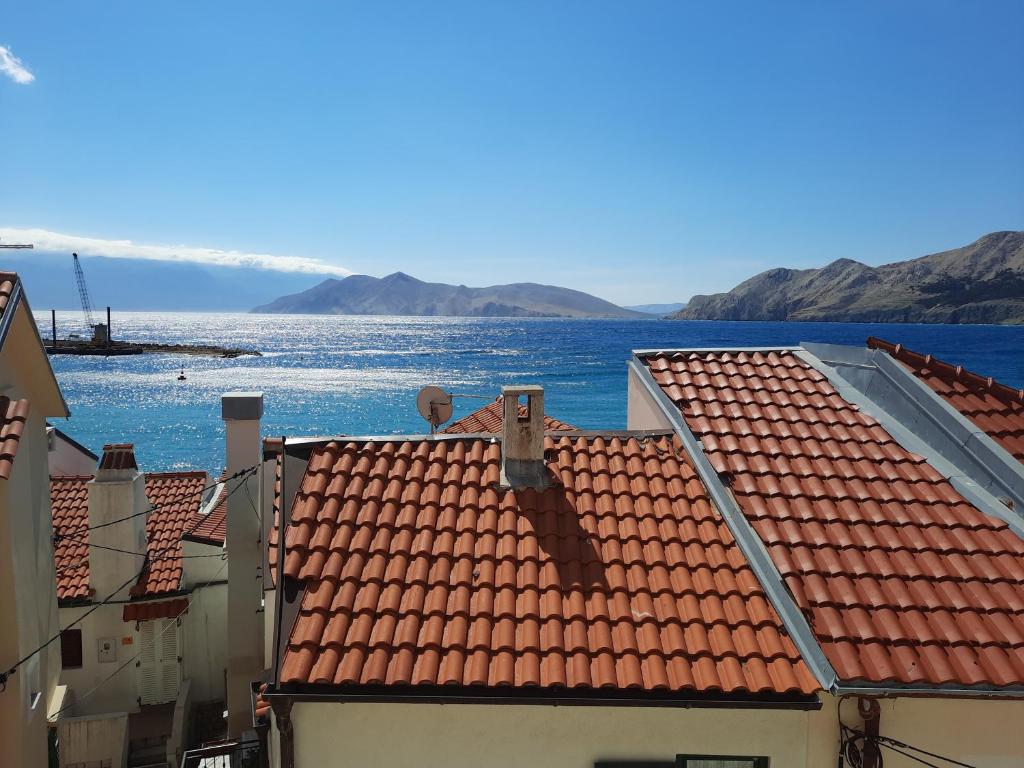 uma vista para o oceano a partir dos telhados dos edifícios em Apartments Alfa em Baska