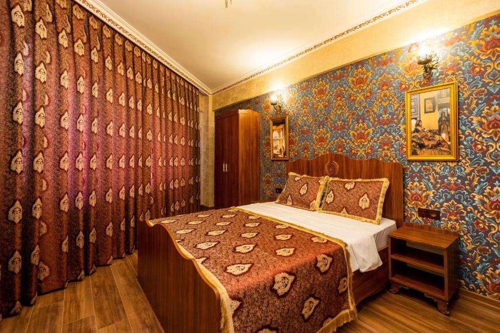 a bedroom with a bed in a room with wallpaper at The First Ottoman Dream in Istanbul