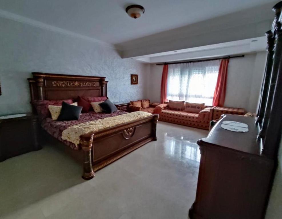 a bedroom with a large bed and a couch at MARINA AGADIR in Agadir