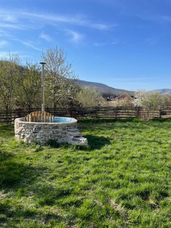 a stone fountain in a field with a fence at Smart and Cozy Nature House in Belogradchik