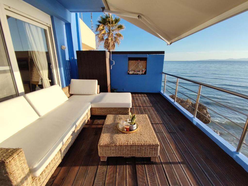 einen Balkon auf einem Kreuzfahrtschiff mit Sofa und Tisch in der Unterkunft La Casa Azul in Arkoudi