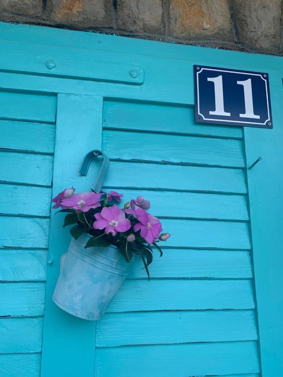 Una puerta azul con una maceta de flores. en Petite house en Starigrad-Paklenica