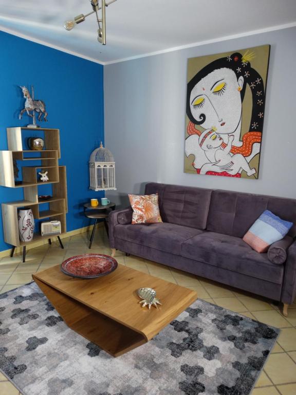 sala de estar con sofá púrpura y mesa en APPARTEMENTY COCO BOLO, en Bourges