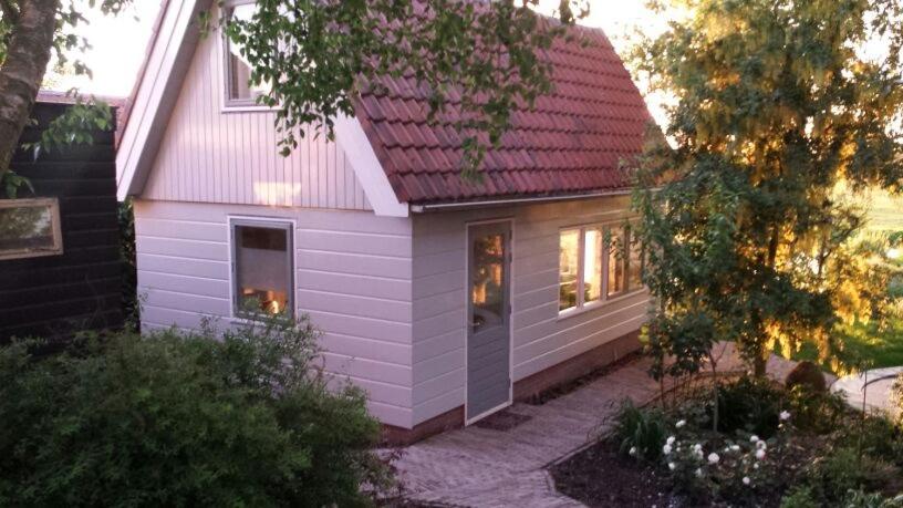 una pequeña casa morada con techo rojo en Very nice cottage in Durgerdam, with private garden, free parking, pets allowed, en Ámsterdam