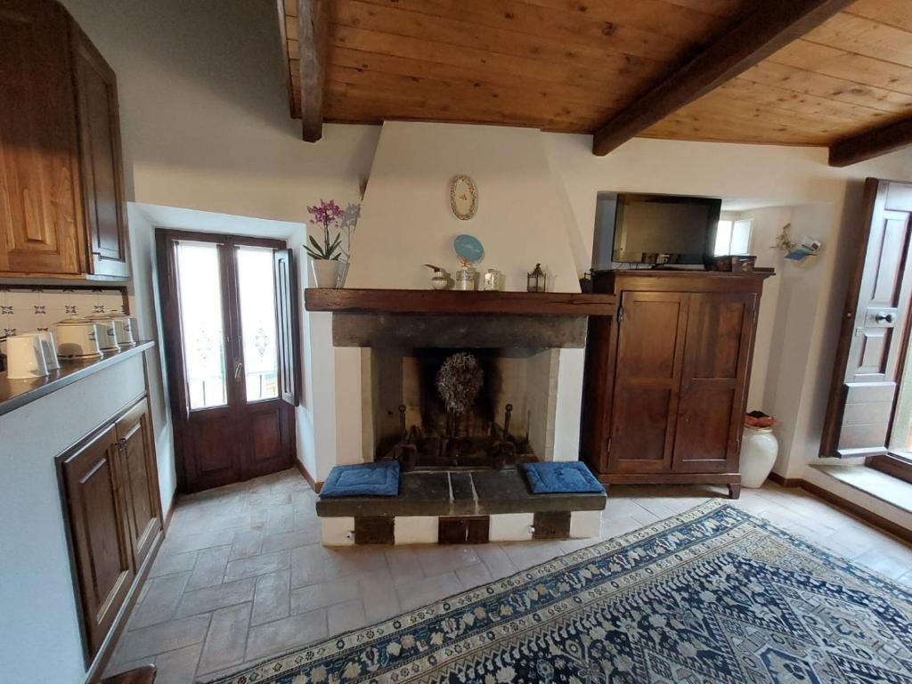 a living room with a fireplace in a kitchen at Casa di Corte in Scansano