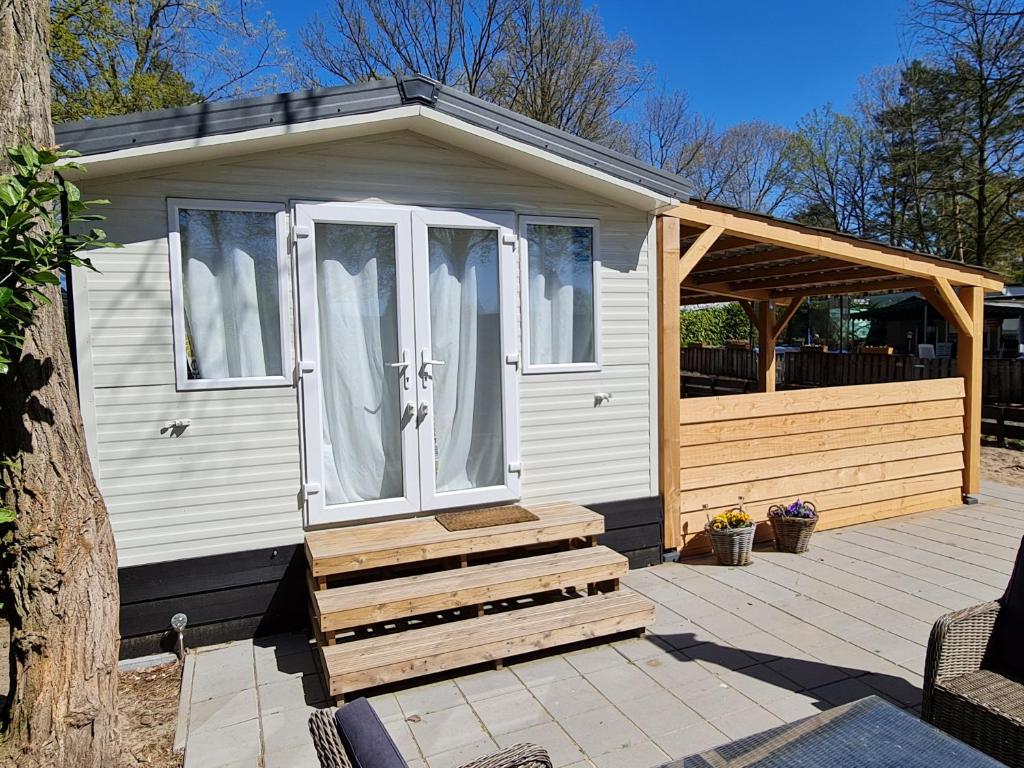 een tiny house met een veranda en een terras bij Chalet Casablanca, 80m2 met veel comfort op fantastisch 5-sterren vakantiepark met zwembaden in Sevenum