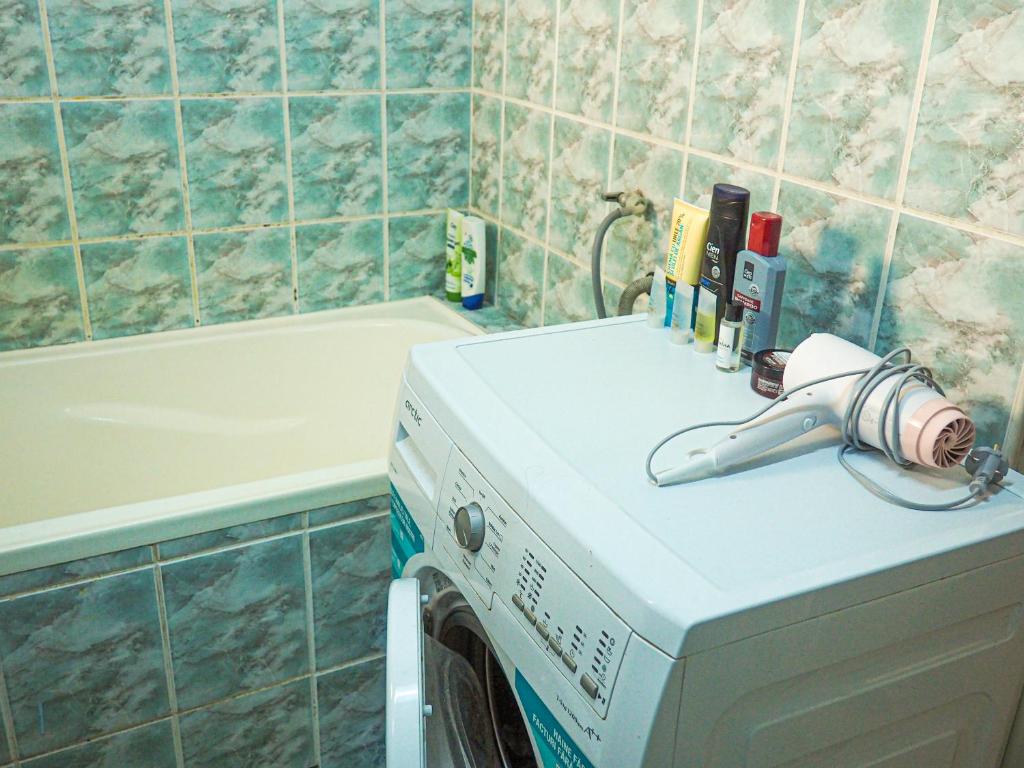 a washing machine in a bathroom next to a bath tub at Modern Room With A Great Sunrise in Timişoara