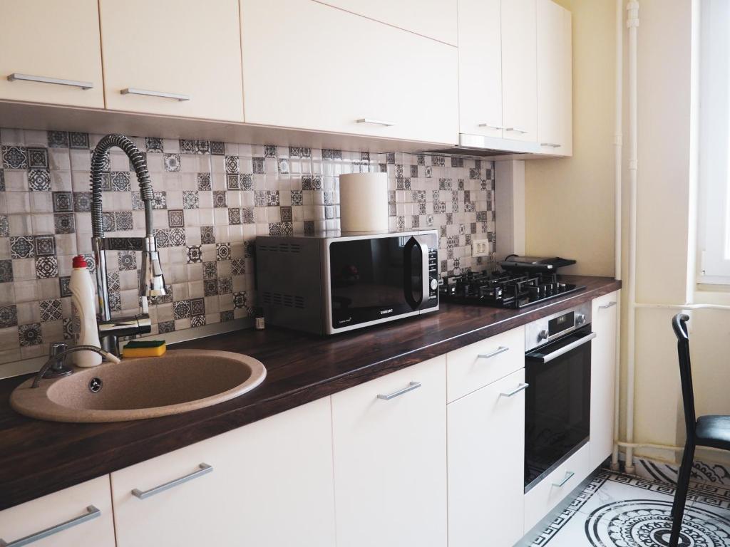 a kitchen with a sink and a microwave at Modern Room With A Great Sunrise - close to the center - in Timişoara