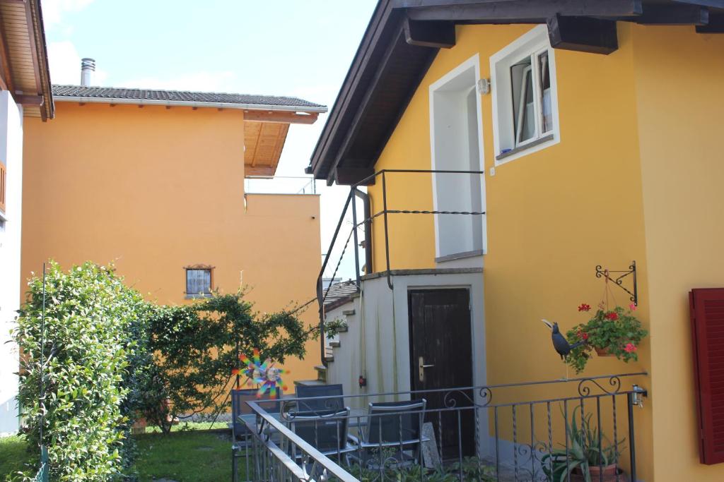 ein gelbes Haus mit einem Vogel auf dem Balkon in der Unterkunft Casa Gialla in Gordola