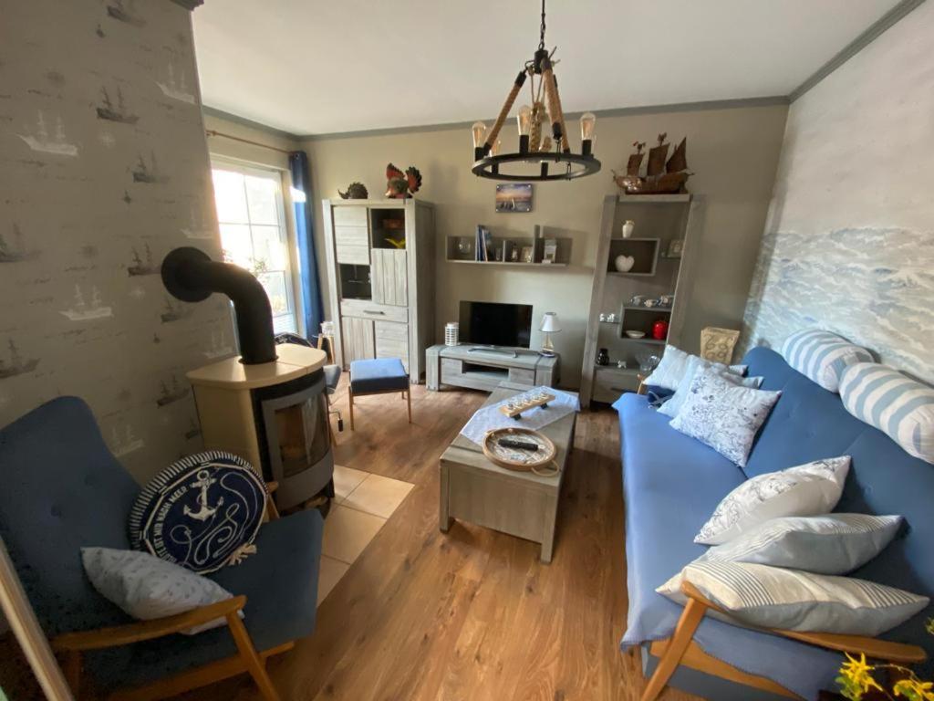 een woonkamer met een blauwe bank en een fornuis bij Ferienwohnung Emily in Ahlbeck