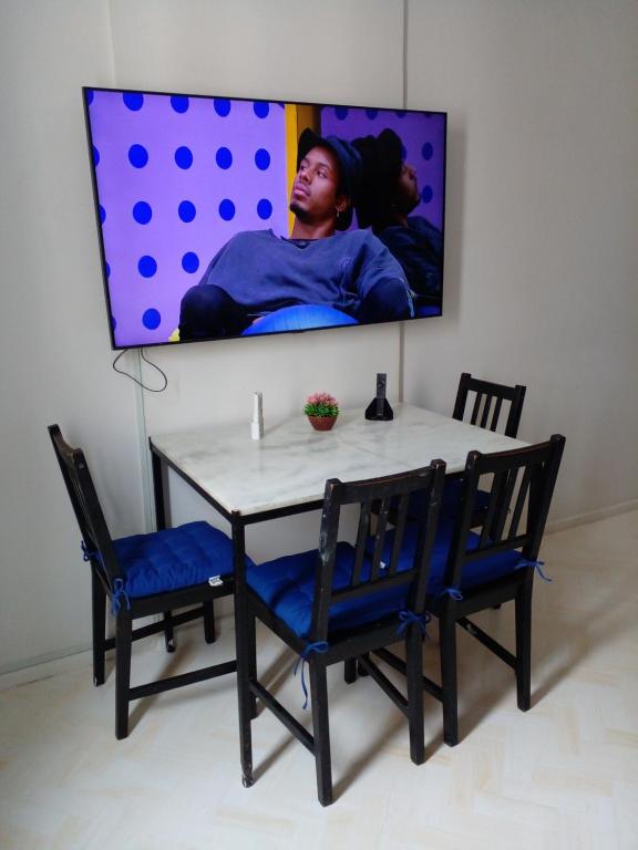 een tafel met twee stoelen en een tv aan een muur bij Top location apartment in Copacabana in Rio de Janeiro