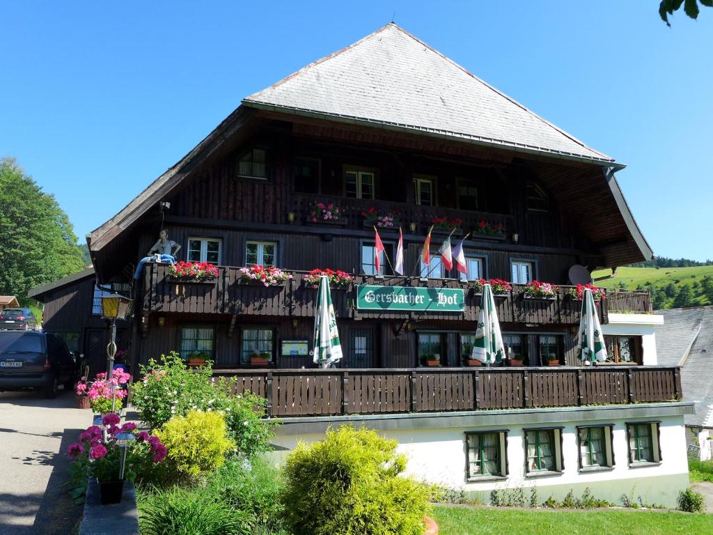 a building with a balcony with flags on it at Genusshotel Gersbacher Hof in Todtmoos