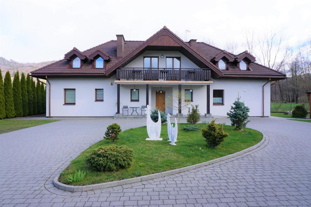 Casa blanca con balcón y entrada en Dworek Góra i Kura, en Brenna