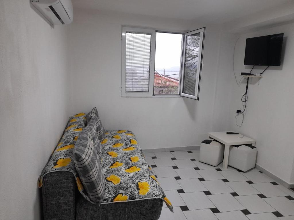 a living room with a couch and a tv at Apartments 64 in Star Dojran