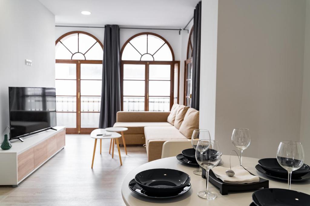 a living room with a couch and a table with wine glasses at ESPINEL APARTMENTS in Ronda
