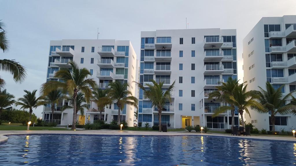 リオ・アトにあるAlquiler de Apartamento en Playa Blancaのプールからアパートメントの建物を望めます。