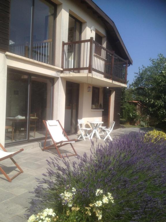 ein Haus mit zwei Stühlen und einem Tisch davor in der Unterkunft Maison sur la colline cheminée WIFI proche Thermes in Aubin