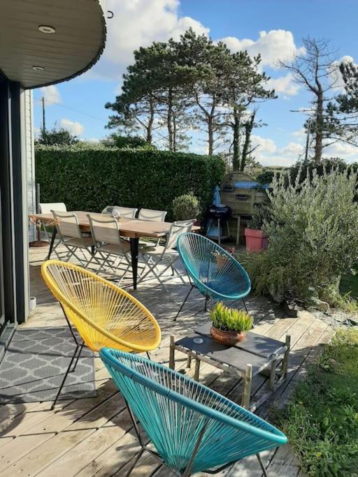 d'une terrasse avec des chaises, une table, une table et des chaises. dans l'établissement Maison Chaleureuse Bord de Mer, à Primelin