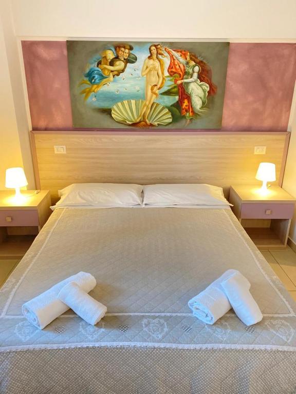 łóżko z dwoma ręcznikami i obrazem w obiekcie Nice Residence we Florencji