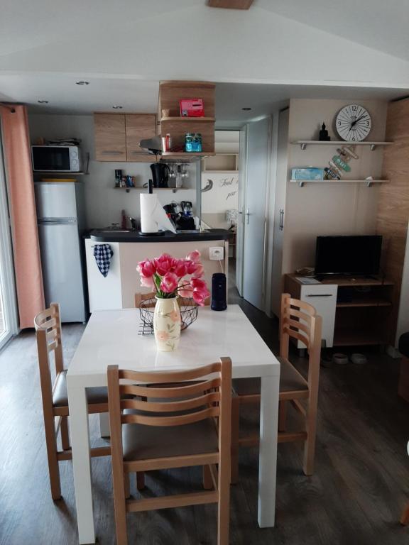 une cuisine avec une table et un vase de fleurs. dans l'établissement LA CARABASSE CP90, à Vias