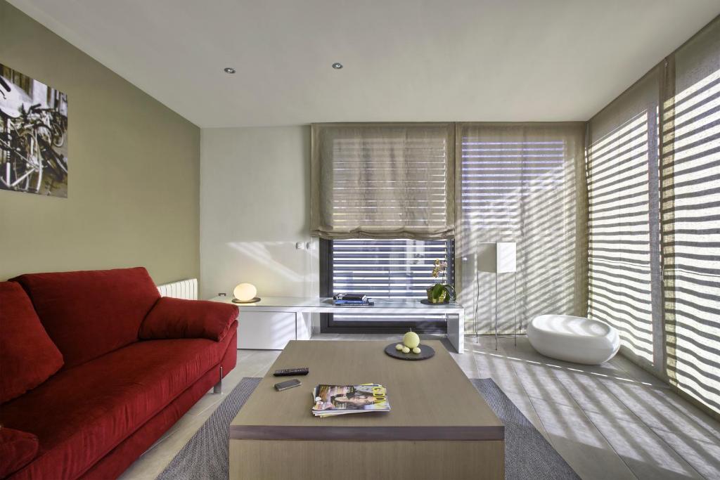a living room with a red couch and a table at Apartaments Terraza Figueres in Figueres