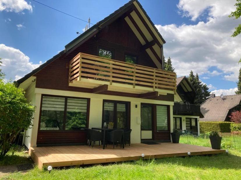 ein Haus mit einer Terrasse und einem Balkon in der Unterkunft Ferienhaus Lilly am Silbersee in Frielendorf