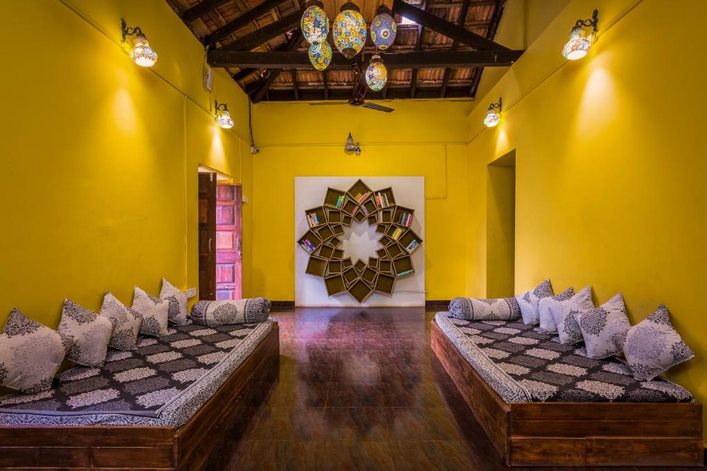 una habitación con sofás y un tablero de ajedrez en la pared en The Funky Monkey Hostel, en Anjuna
