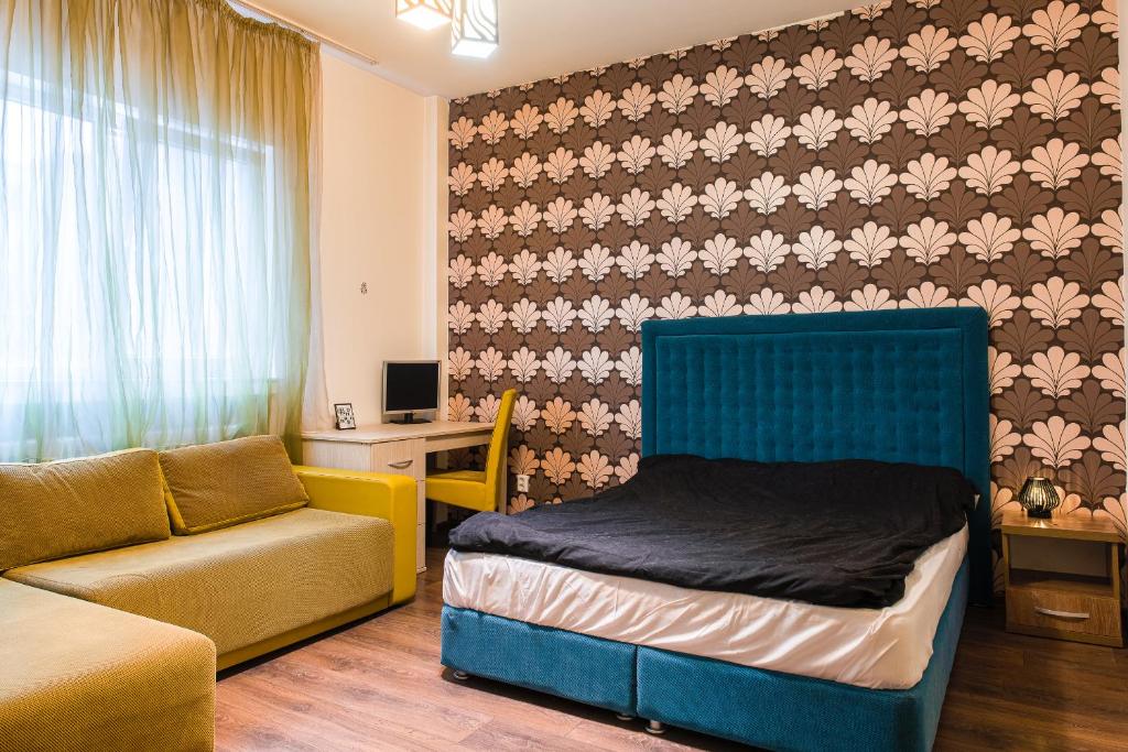 a bedroom with a bed and a couch in a room at Apartament Ultracentral, Piata Romana in Bucharest