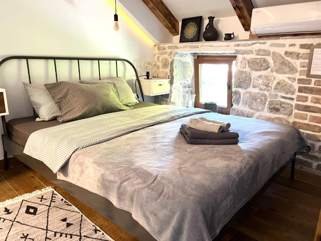 Bett in einem Zimmer mit einer Steinmauer in der Unterkunft HealthyStudio512 Apartments in Kotor