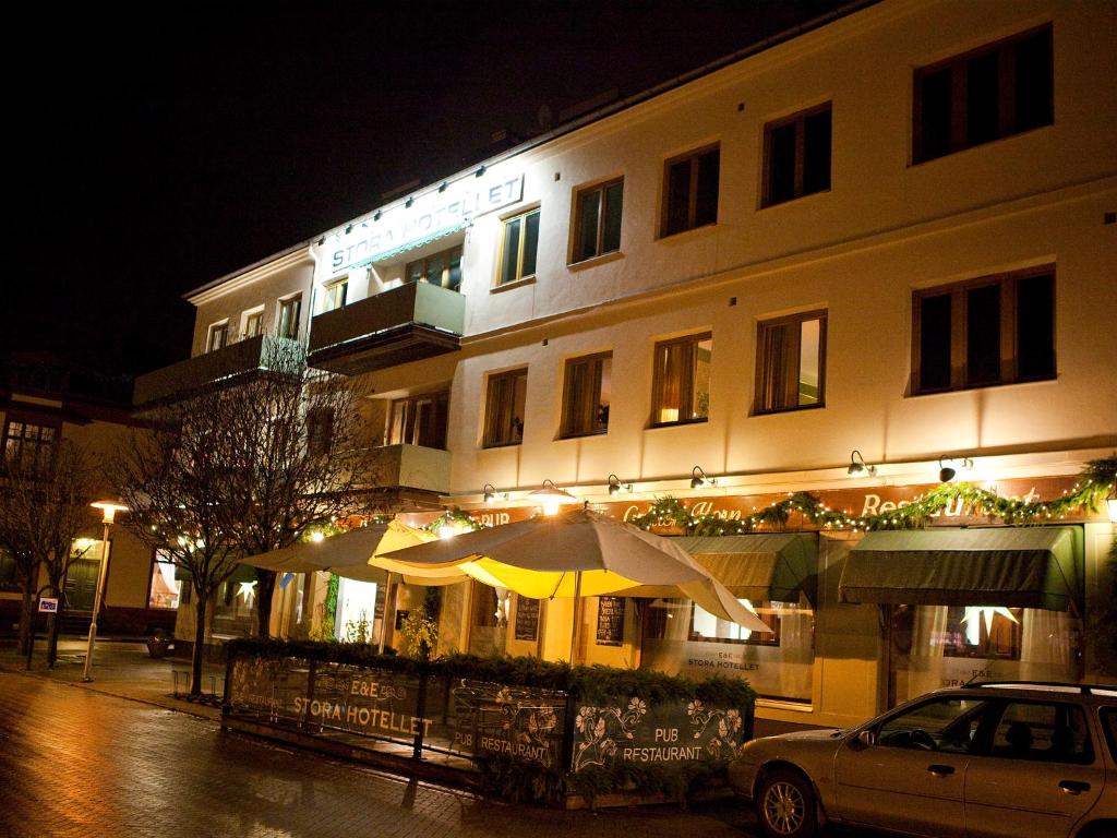 a building with umbrellas on a street at night at Stora Hotellet Osby in Osby