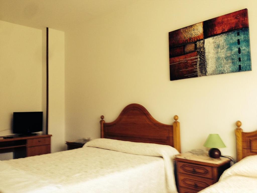 A bed or beds in a room at Pensión Glorioso II