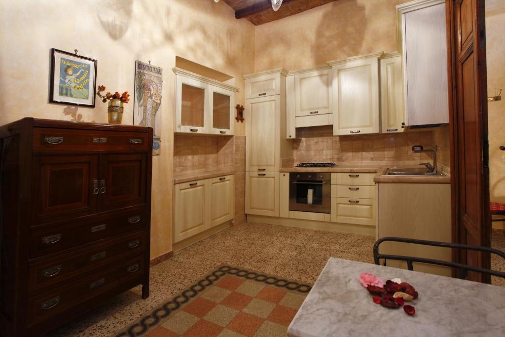 a kitchen with white cabinets and a table in it at Casa Vacanza Colosseo in Rome