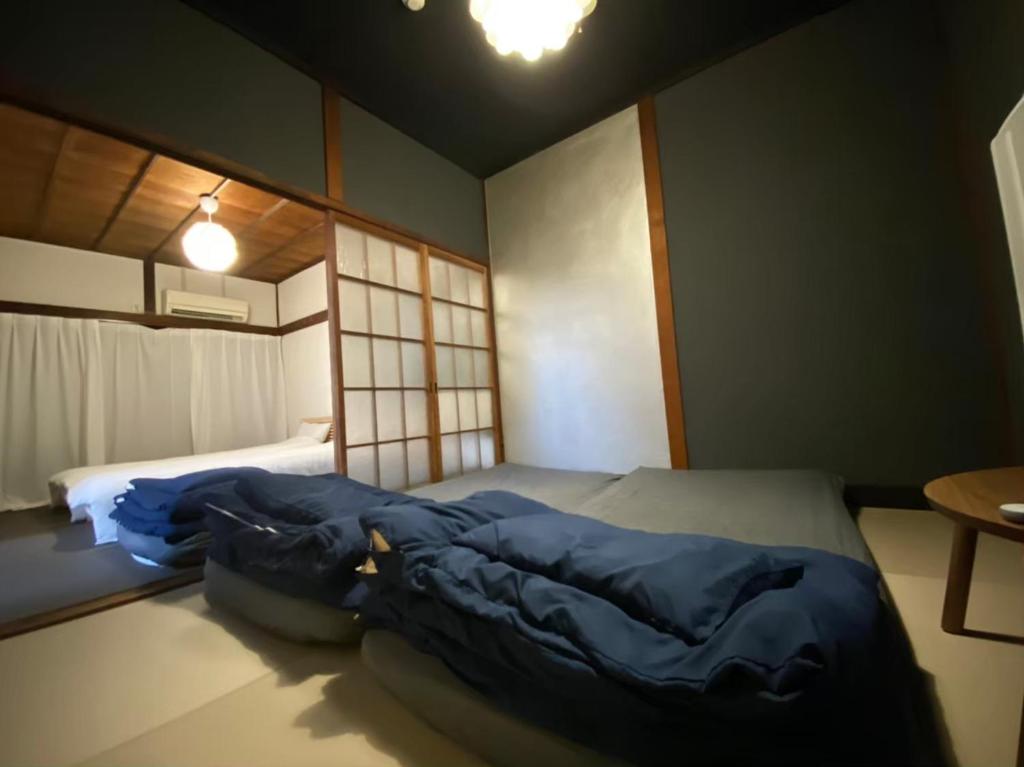 a bedroom with a bed with blue comforter at TATAMI l in Yokohama