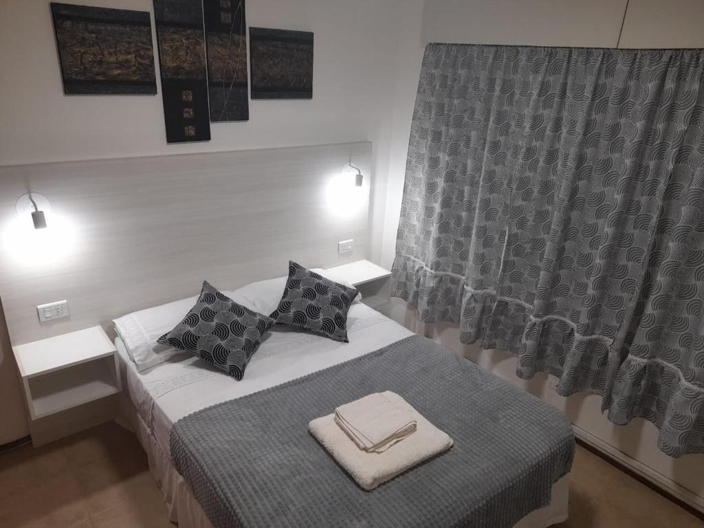 a bedroom with a bed with two pillows and a window at Departamento Céntrico en Mendoza in Mendoza