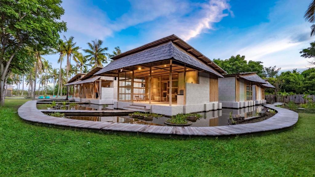 a house in the middle of a yard at Pravasa Gili Resort by KajaNe in Gili Meno