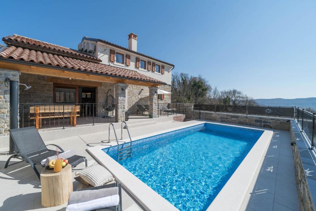 een villa met een zwembad en een huis bij Villa Poji in Buzet