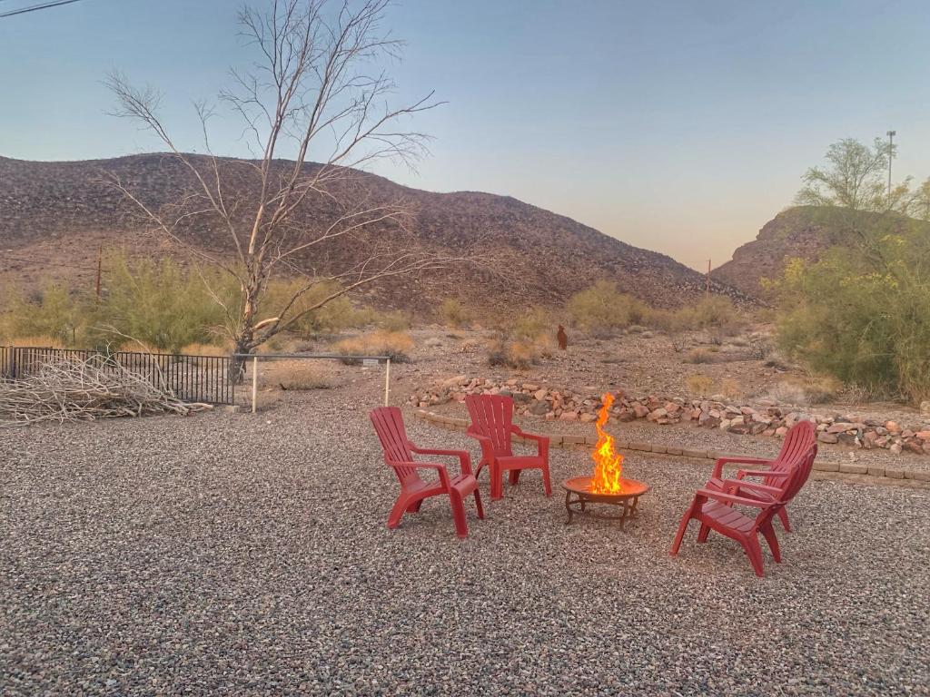 a group of red chairs and a fire pit at Desert Getaway - Centrally Located, Trail Access Steps Away! in Lake Havasu City