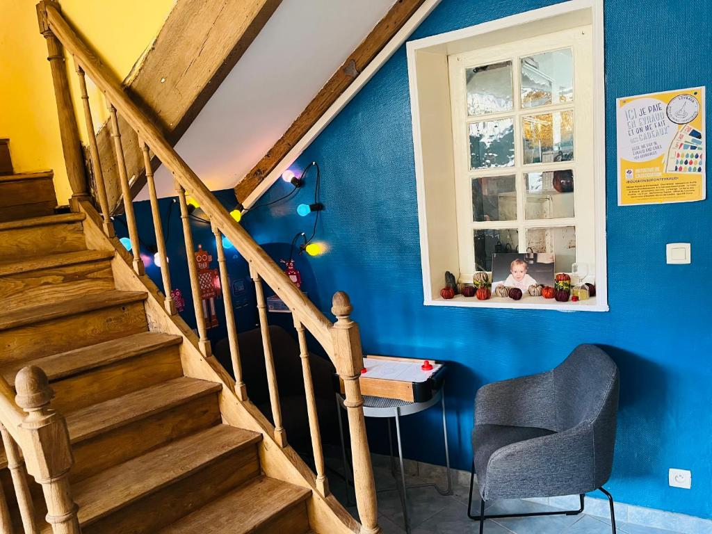 a staircase in a room with a blue wall at Chez mimie les hôtes in Fontevraud-l&#39;Abbaye